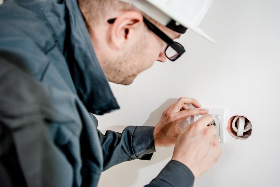 Electrician installing a wall outlet