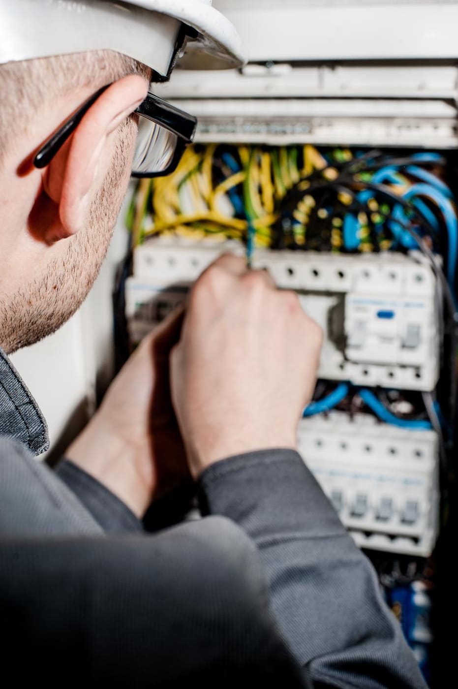 Electrician working inside a breaker panel